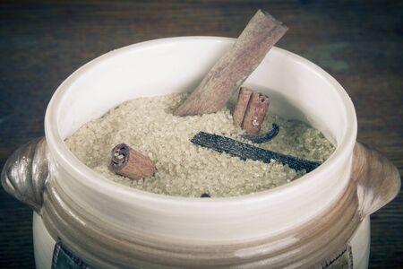 Brown sugar and spices on dark wooden background in ceramic ware. tintedの写真素材