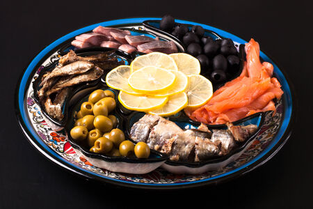 Assorted fish on a plate on a dark background.の写真素材