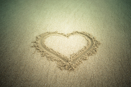 Heart drawn in the sand. Beach background. Tintedの写真素材