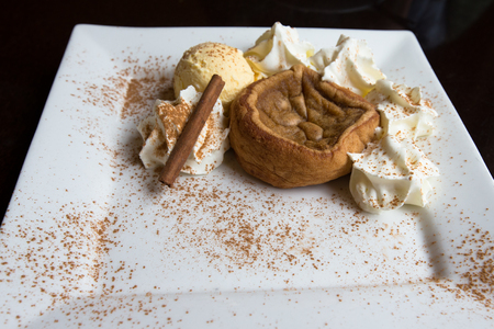 Traditional Portuguese cake "pasteis de nata"  with ice cream, decorated with cinnamon and cocoaの写真素材