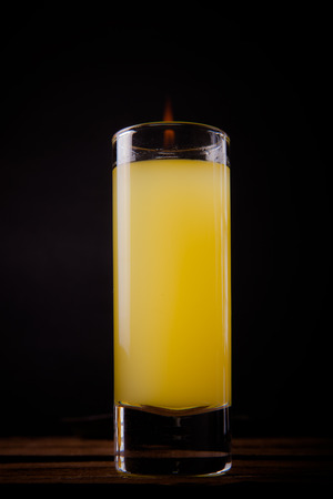 glass with a drink by the fire on a black backgroundの写真素材
