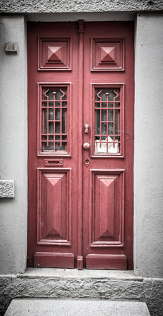 Old red wooden door with window and grid. Toned.の写真素材