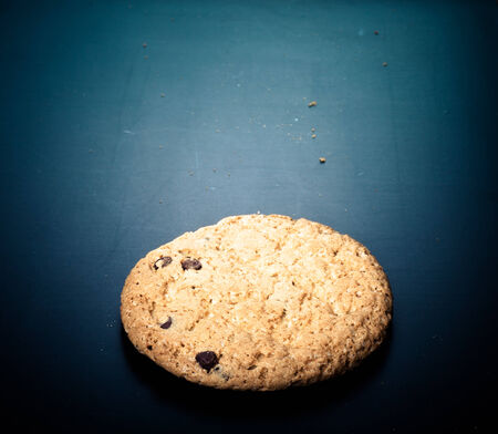 Oat cookie on the old black shabby background. Toned.の写真素材
