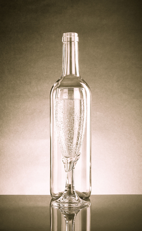 Empty bottle and glass with a pop of transparent glass. Standing each other. With Reflectionの写真素材