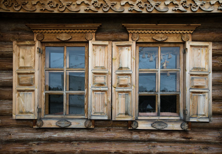 Windows with shutters, patterned on the wall of the old wooden house.の写真素材