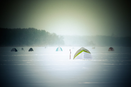 Tents on the snow-covered field near the forest.の写真素材