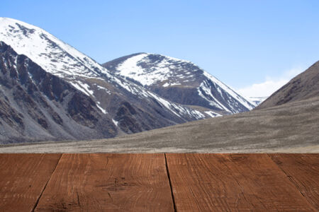 Wood flooring with a view of the sky over the mountains.の写真素材
