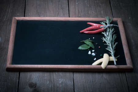 Herbs and spices. Red pepper, salt and rosmary on a black background. With space for text. Toned.の写真素材