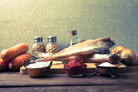 Still life with fish, vegetables and spices on a wooden board. Toned.の写真素材