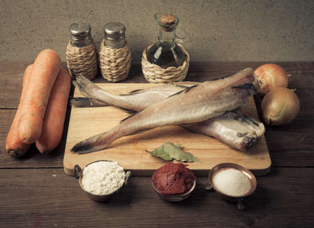Still life with fish, vegetables and spices on a wooden board. Toned.の写真素材
