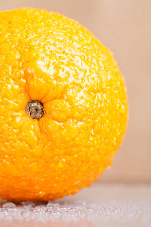 Orange with water drops on the skin close-up on a light background. Shallow depth of field.の写真素材