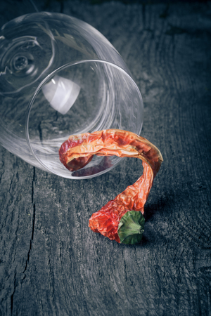 red hot chili peppers in a glass on a dark wooden backgroundの写真素材