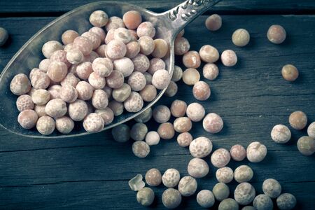 dry peas in a silver spoon on a wooden table. の写真素材