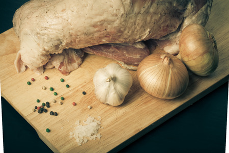 Raw meat, onion, garlic and spices on a wooden board. Toned.の写真素材