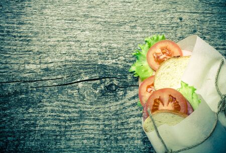 sandwich bandaged twine on a textured wooden board. tintedの写真素材