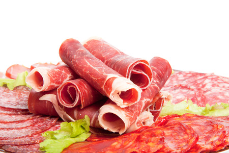 Slices of different kinds of meat with green salad.の写真素材