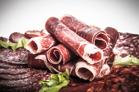 Slices of different kinds of meat with green salad. Toned.の写真素材