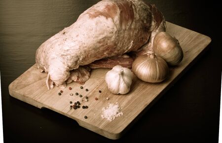 Raw meat, onion, garlic and spices on a wooden board. Toned.の写真素材