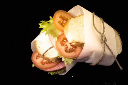 sandwich with sausage bandaged twine on a black background. の写真素材
