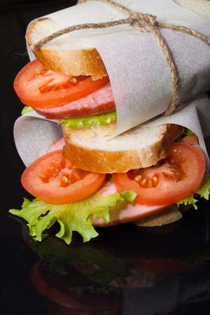 sandwich with sausage bandaged twine on a black background.の写真素材