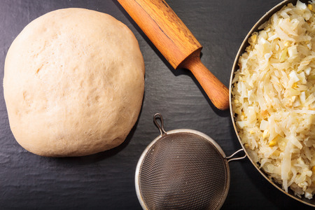 Rolling pin, dough and a cabbage filling for pie.の写真素材