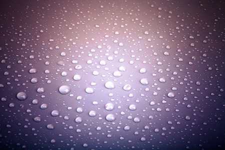 Drops of water on the colored background.の写真素材