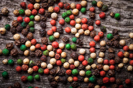 Colorful peppercorns on an old wooden table. Toned.の写真素材