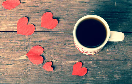 Valentine hearts and cup of tea on the old wooden table. Toned.の写真素材