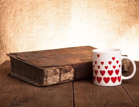 Cup of coffee, old books on the old wooden table.の写真素材