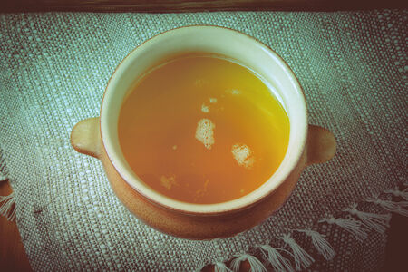 Clay pot with ghee on linen napkin. Rustic still life. Wooden background. Toned.の写真素材