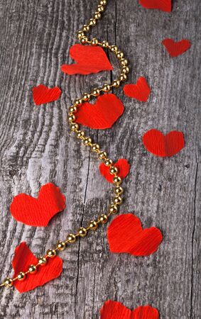 Many Valentine hearts and shiny beads on the old wooden table.の写真素材