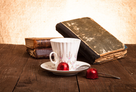 Cup of coffee, shokolad and stack of old books on the old wooden table. Toned.の写真素材