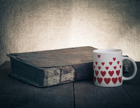 Cup of coffee, old books on the old wooden table.の写真素材
