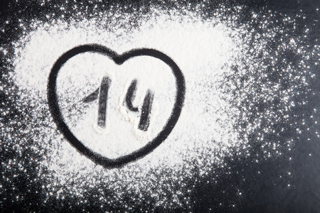 Shape of heart drawn on the flour on a black background.の写真素材