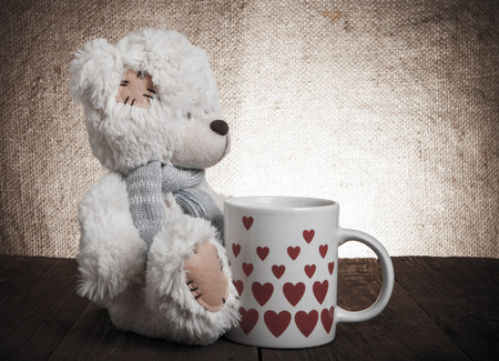 bear with a cup with hearts on the background of sackingの写真素材
