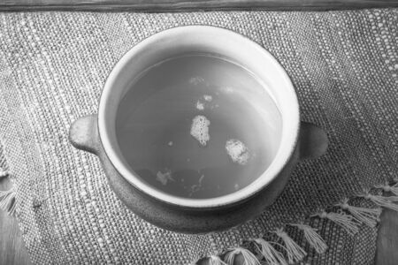 Clay pot with ghee on linen napkin. Rustic still life. Wooden background. Toned.の写真素材