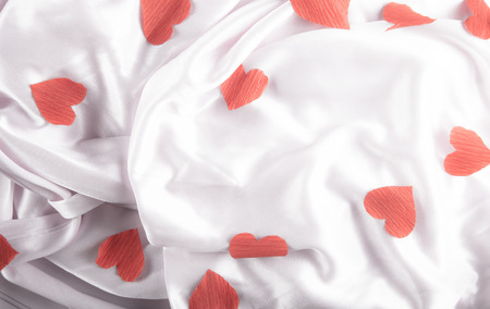 Pink silk with red paper hearts.の写真素材