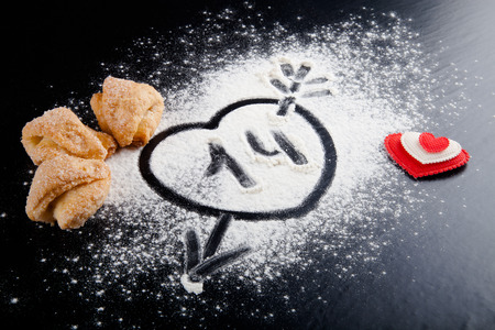 14. Heart with arrow on the flour on the black table. Cookies and red heart.の写真素材