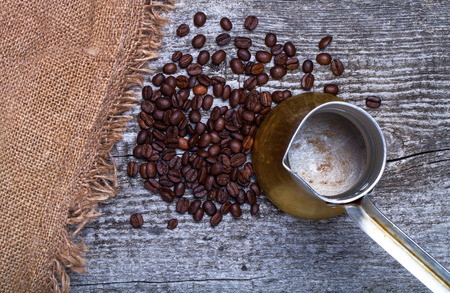 Coffee turk and coffee beans on old gray wooden table with burlap.の写真素材