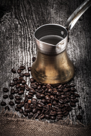 Coffee turk and coffee beans on old gray wooden table with burlap. Toned.の写真素材