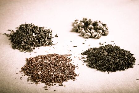 Four kinds of tea on a paper background. Toned.の写真素材