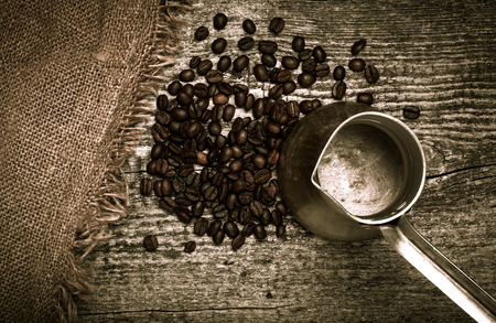 Coffee turk and coffee beans on old gray wooden table with burlap. Toned.の写真素材