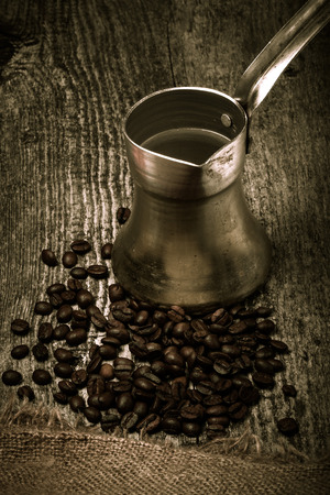 Coffee turk and coffee beans on old gray wooden table with burlap. Toned.の写真素材