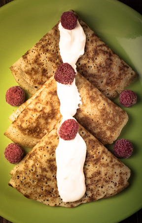 Russian pancakes - blini with sour cream and raspberry. Toned.の写真素材