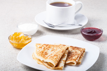 Cup of tea with jam, sour cream and russian pancakes - blini.の写真素材