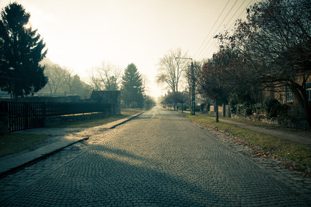 Provincial European town street paved with tiles. Autumn. Toned.の写真素材