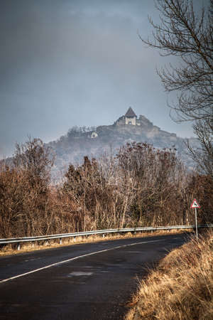 Paved country road in autumn. Clear blue sky and house on the hill. Toned.の写真素材