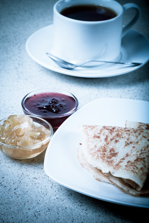 Russian pancakes - blini with cup of tea and jam. Toned.の写真素材
