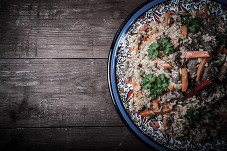 Delicious pilaf on a turkish plate on old wooden table. Rustic style. Toned.の写真素材
