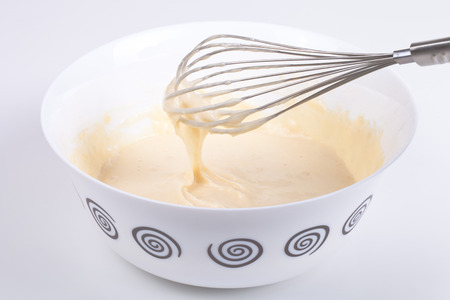 Mixed batter in a bowl and whisk.の写真素材